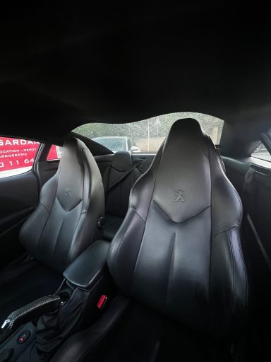 Intérieur de voiture avec sièges baquets en cuir noir, vue sur la console centrale.
